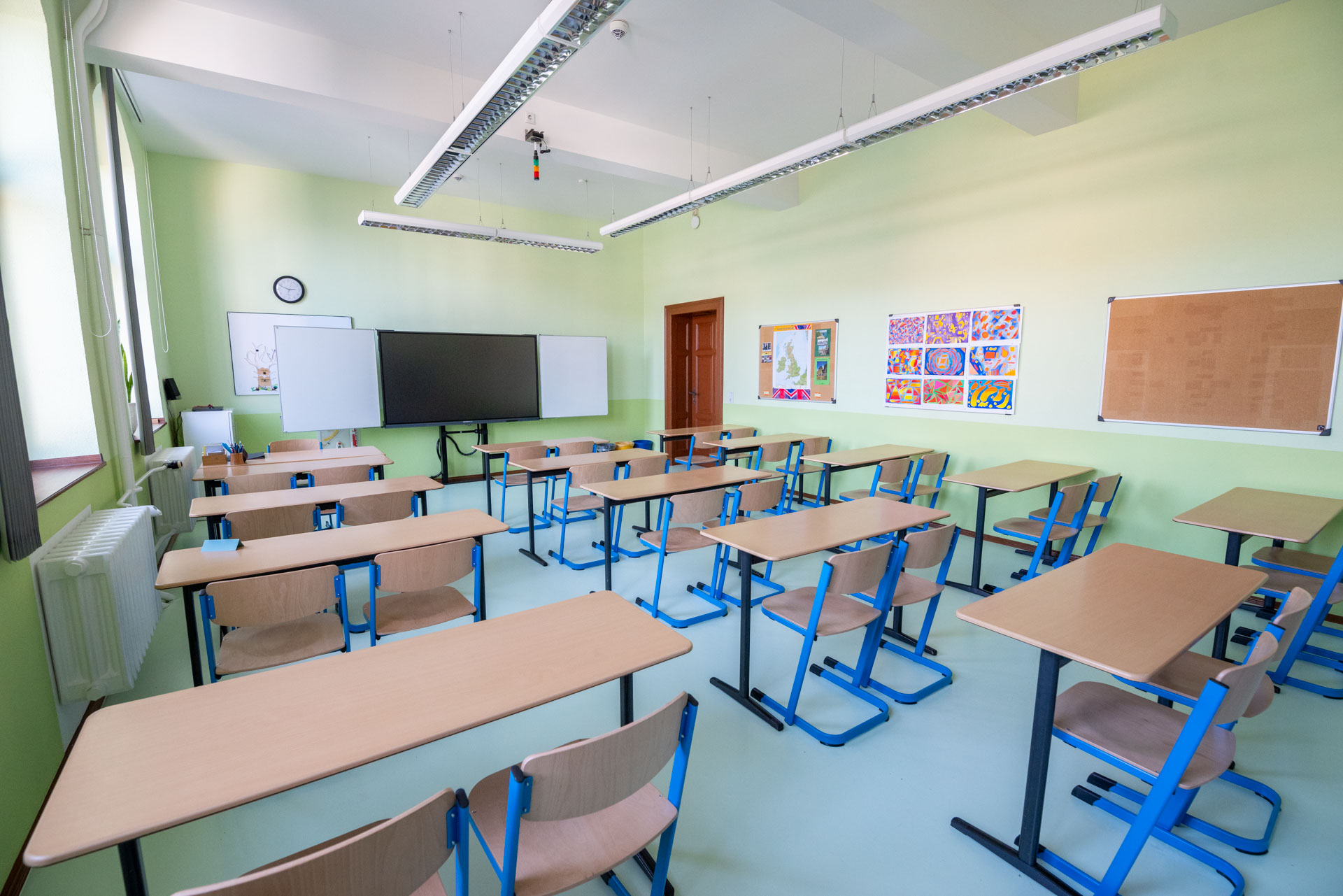 Klassenraumansicht mit Tischen und Tafel